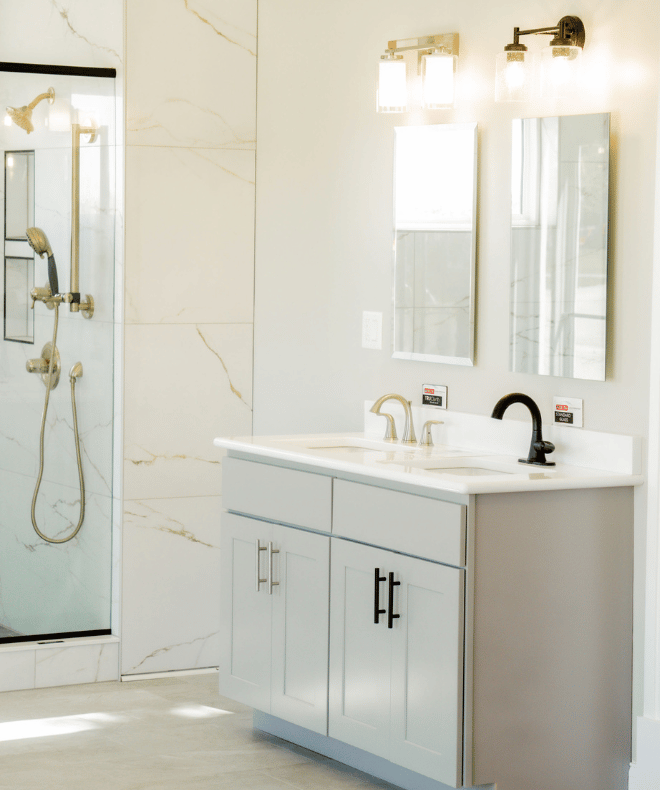 Bathroom remodel with white shaker vanity, quartz countertop, and large format marble tile shower by C-U Under Construction in Champaign, IL
