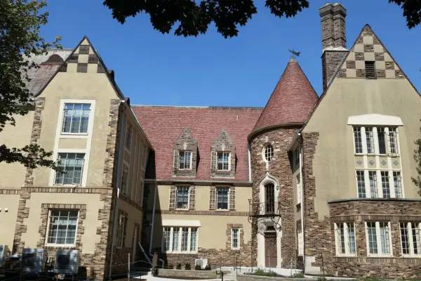 Historic stone building with Gothic architecture and red tile roof